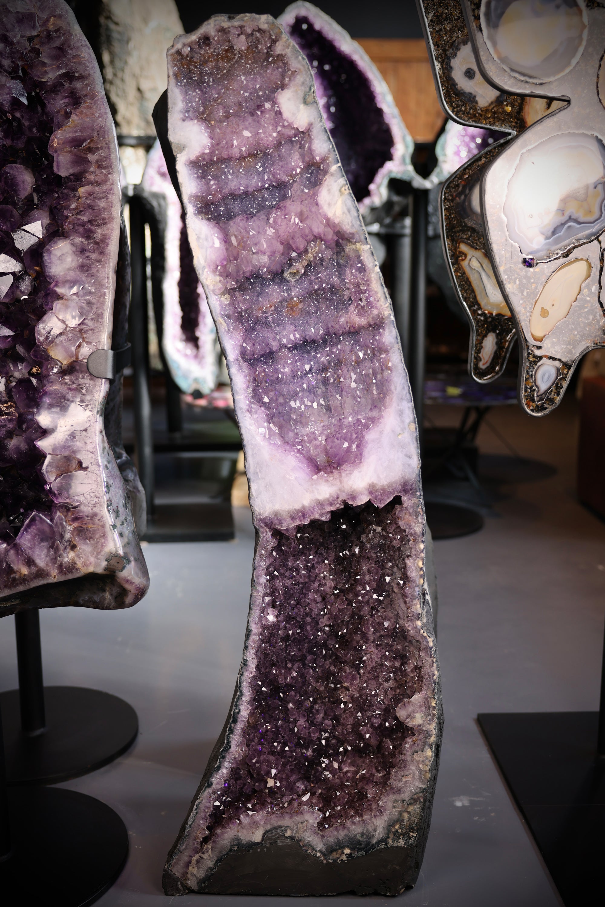 Nahaufnahme einer Amethyst-Druse mit violetten Quarzkristallen und sichtbarer Kristallspitzenstruktur.