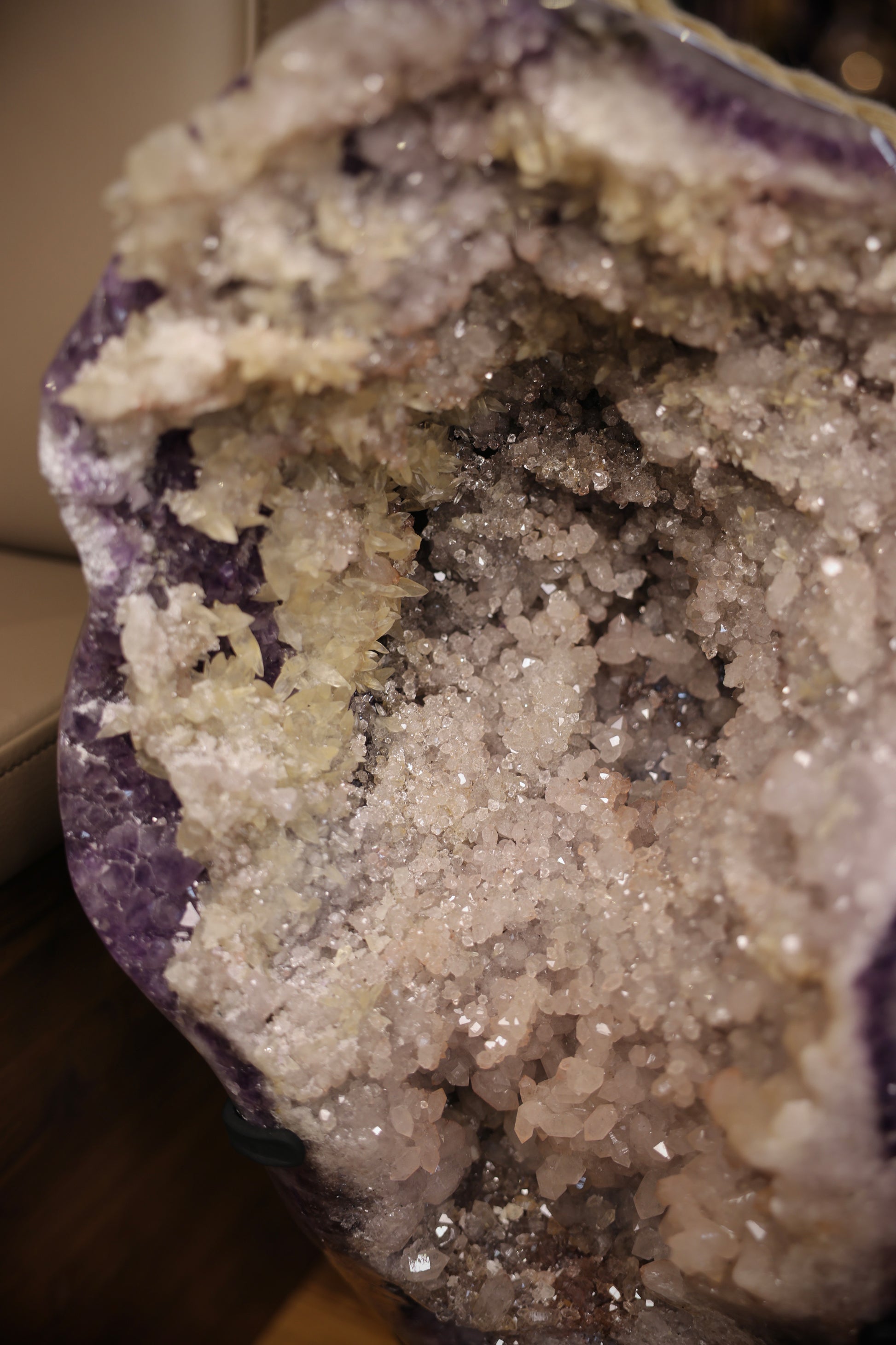 30,6 kg schwere Amethyst Druse aus Brasilien mit dichter Sugaring-Struktur und hellen Calcit-Kristallen auf Standfuß