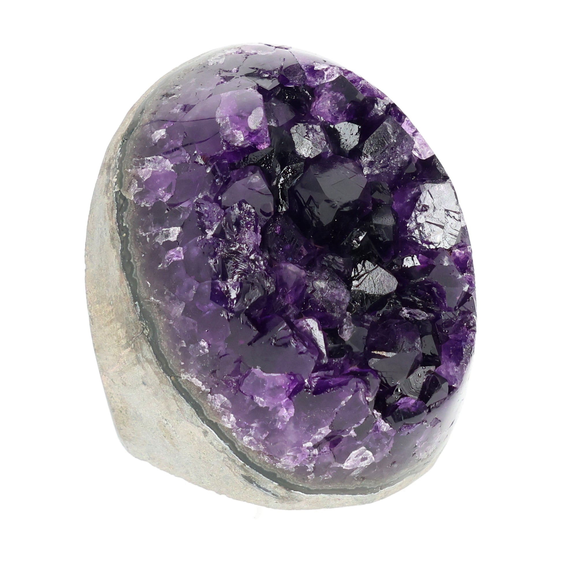 Mehrere hochwertige Amethyst Mini Cut Bases aus Uruguay mit dicht gewachsenen, tiefvioletten Kristallen auf einer Präsentationsfläche.
