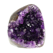 Mehrere hochwertige Amethyst Mini Cut Bases aus Uruguay mit dicht gewachsenen, tiefvioletten Kristallen auf einer Präsentationsfläche.