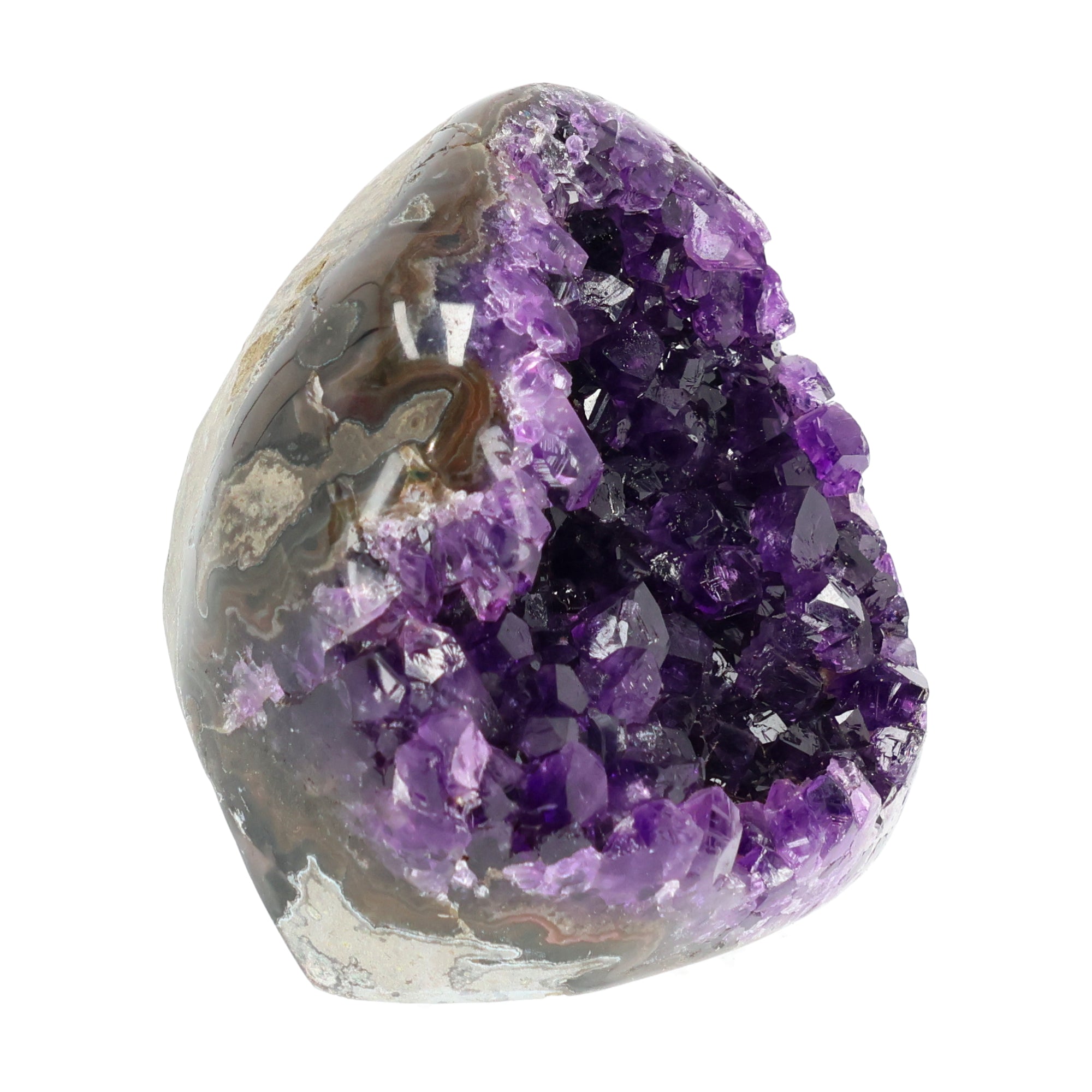 Mehrere hochwertige Amethyst Mini Cut Bases aus Uruguay mit dicht gewachsenen, tiefvioletten Kristallen auf einer Präsentationsfläche.