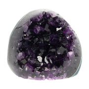 Mehrere hochwertige Amethyst Mini Cut Bases aus Uruguay mit dicht gewachsenen, tiefvioletten Kristallen auf einer Präsentationsfläche.