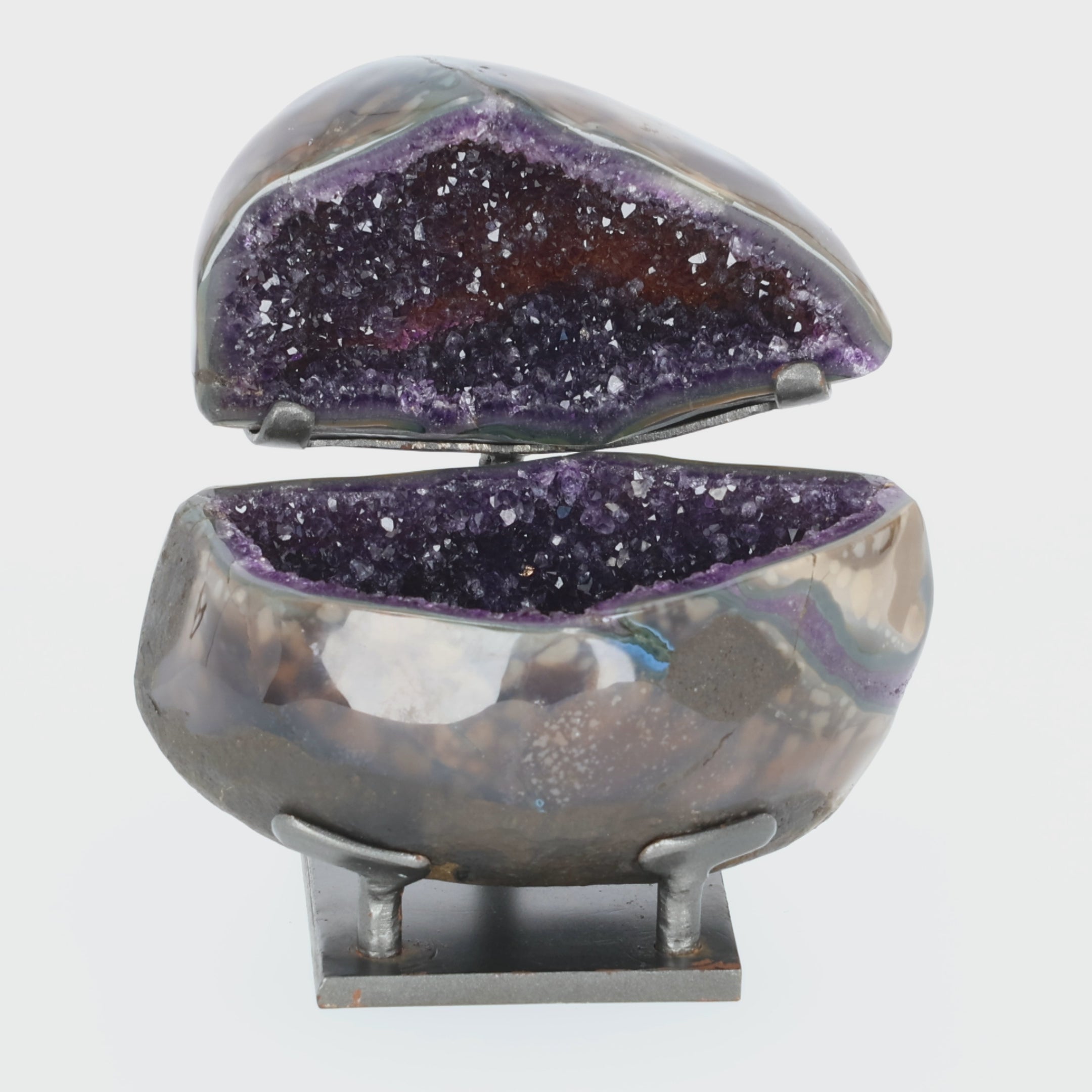 Load video: Amethyst Geoden-Juwelenbox aus Uruguay auf Metallstandfuß mit geöffneter Geode und violetter Kristalldruse im Inneren.