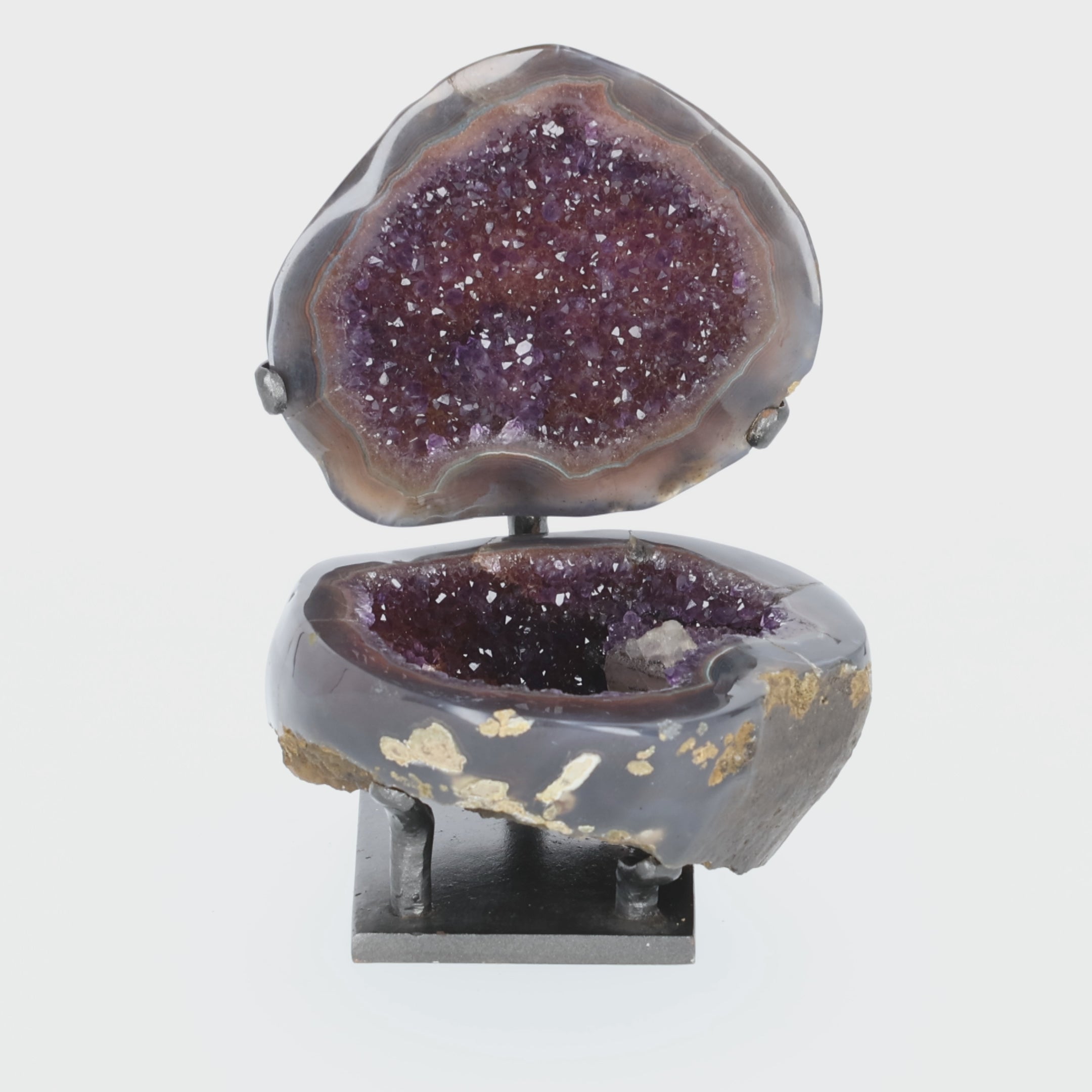 Video laden: Amethyst Geoden-Juwelenbox aus Uruguay auf Metallstandfuß mit geöffneter Geode und violetter Kristalldruse im Inneren.
