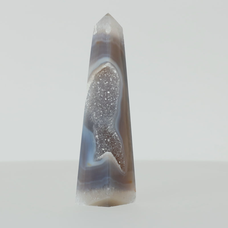 Polierter Achat-Obelisk aus Brasilien mit natürlicher Bänderung und teilweise offener Druzy-Kristallstruktur in Braun-, Grau- und Cremetönen.