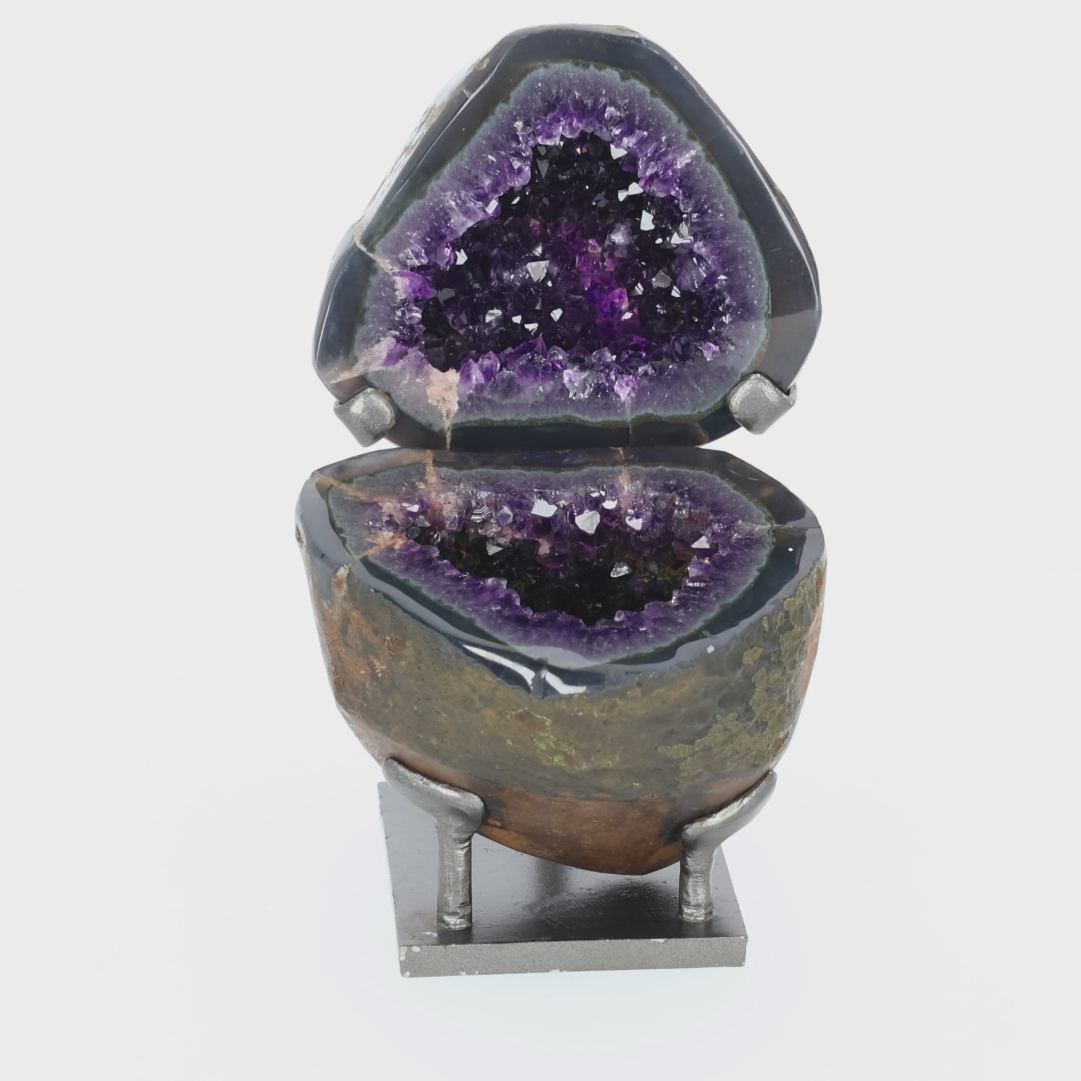 Video laden: Amethyst Geoden-Juwelenbox aus Uruguay auf Metallstandfuß mit geöffneter Geode und violetter Kristalldruse im Inneren.