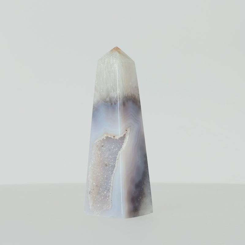Polierter Achat-Obelisk aus Brasilien mit natürlicher Bänderung und teilweise offener Druzy-Kristallstruktur in Braun-, Grau- und Cremetönen.