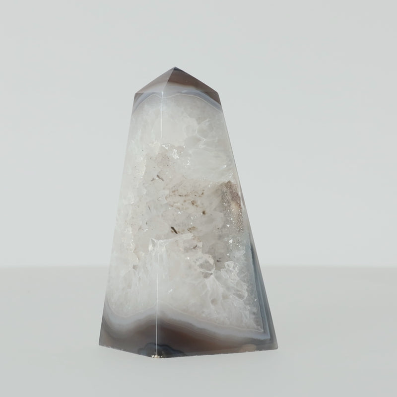 Polierter Achat-Obelisk aus Brasilien mit natürlicher Bänderung und teilweise offener Druzy-Kristallstruktur in Braun-, Grau- und Cremetönen.