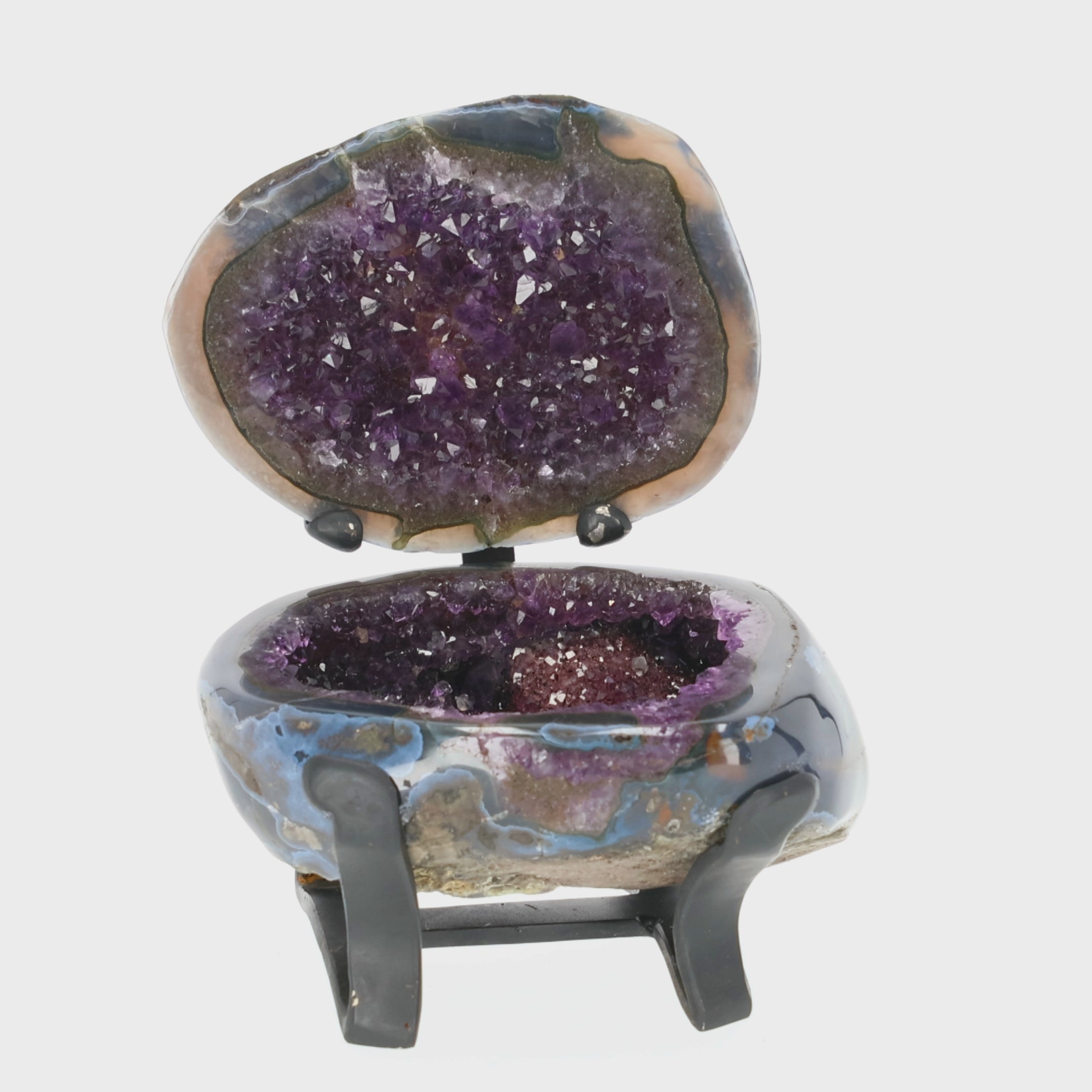 Load video: Amethyst Geoden-Juwelenbox aus Uruguay auf Metallstandfuß mit geöffneter Geode und violetter Kristalldruse im Inneren.