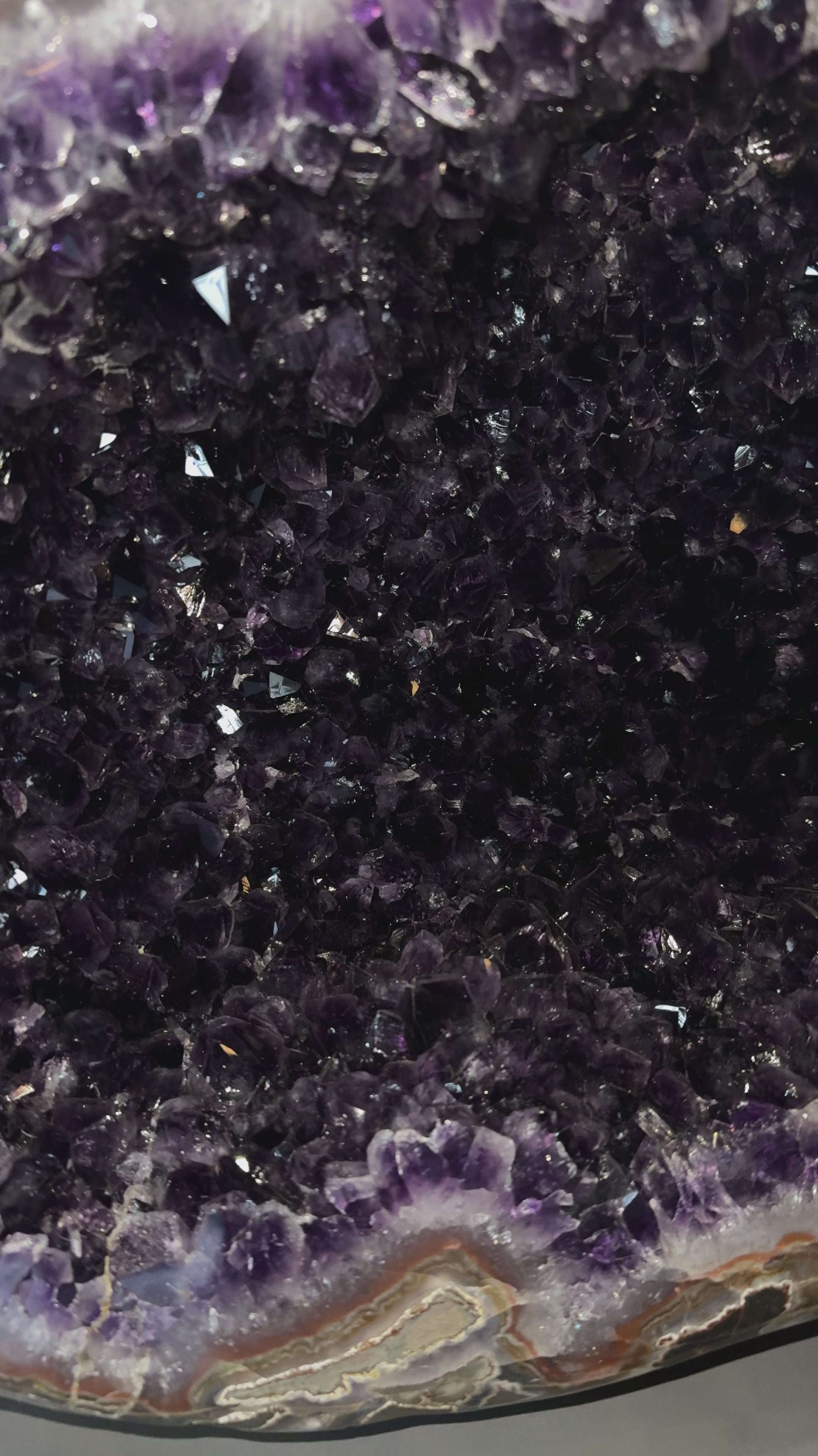 Load video: Große Uruguay Amethyst-Druse mit sehr dunkler violetter Kristallstruktur und natürlichem Achatrand